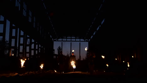 Zeitlupe:-Feuershow-Im-Hangar-Zeigt-Drei-Artistinnen-Und-Einen-Mann-Mit-Flammenwerfern